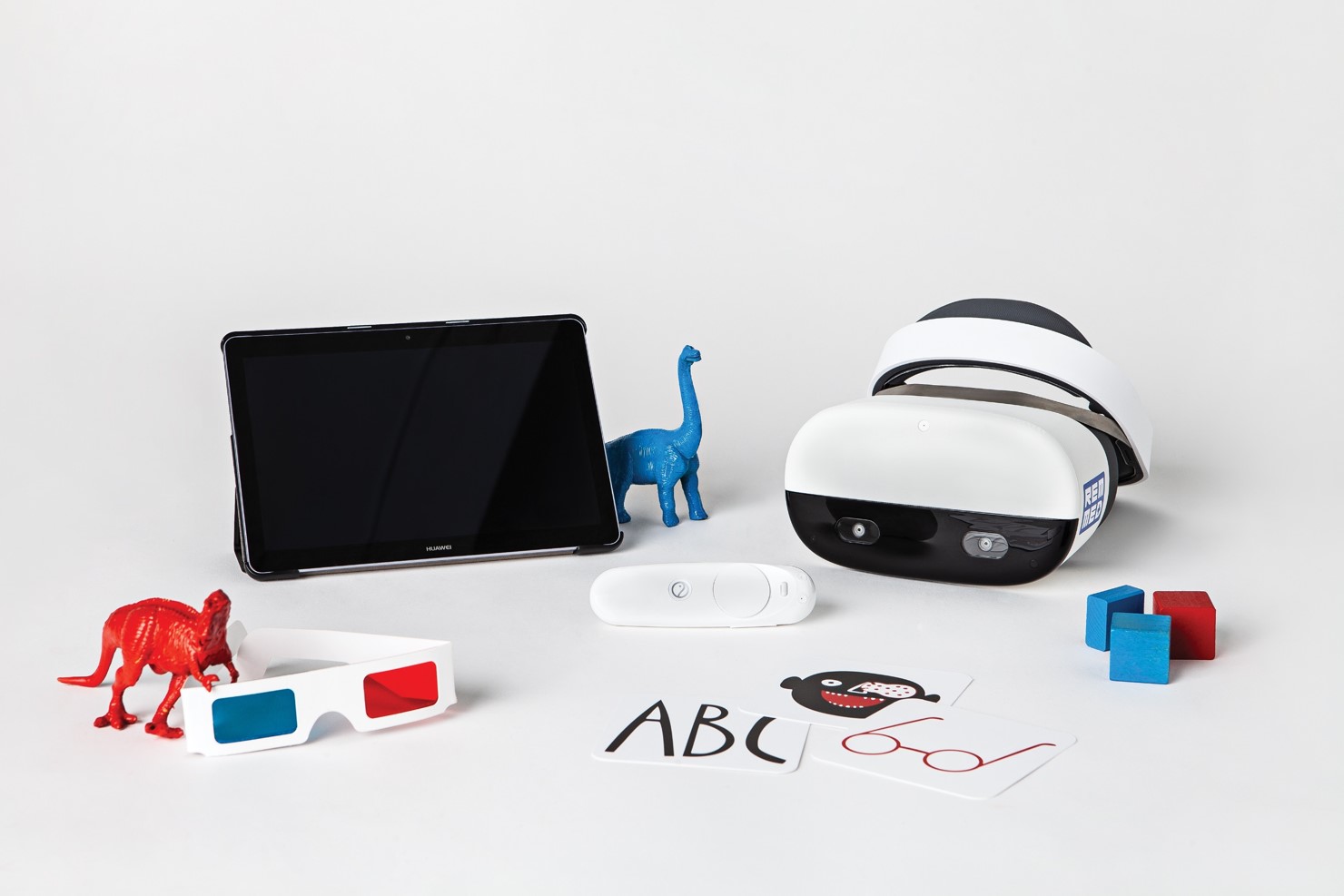 widok na gogle VR, tablet, małe figurki w kształcie dinozaurów oraz kartki - z napisem 