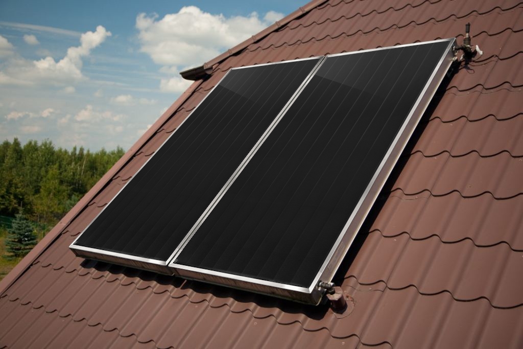 widok na dwa zamontowane obok siebie panele słoneczne leżące na brązowym dachu domu jednorodzinnego